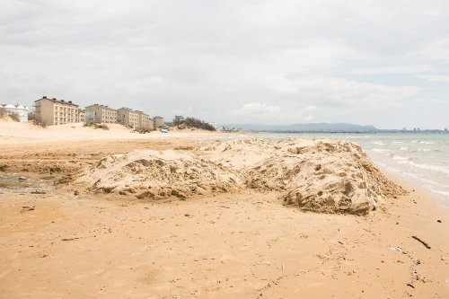 Срытый с дюн песок свален на берегу