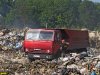 Охраник полигона разговаривает с водителем КАМАЗа, привезшим землю для засыпки горящего мусора