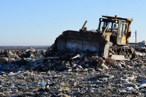 Бульдозер утрамбовывает всё новые слои мусора на Динской свалке