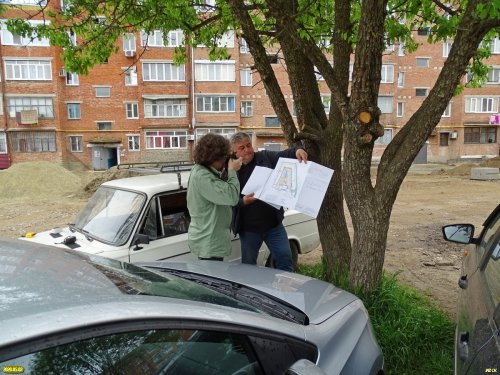 Местный житель дома на Ворошилова,1 в Апшеронске показывает схему проекта "Комфортная городская среда" 